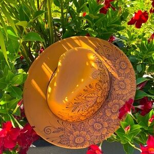 Floral burned design on a brown western cowgirl hat